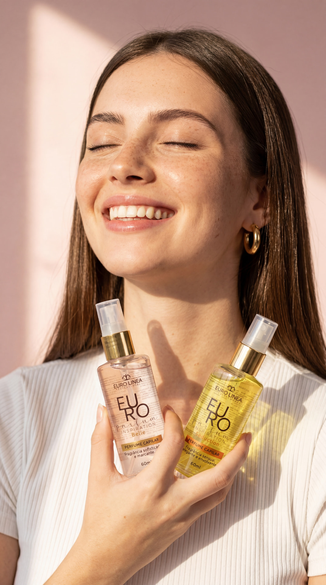 Modelo segurando os perfumes capilares Euro Linea